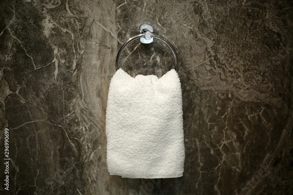 Obraz Face towel isolated hanging on the round circle metal hanger in the restroom.