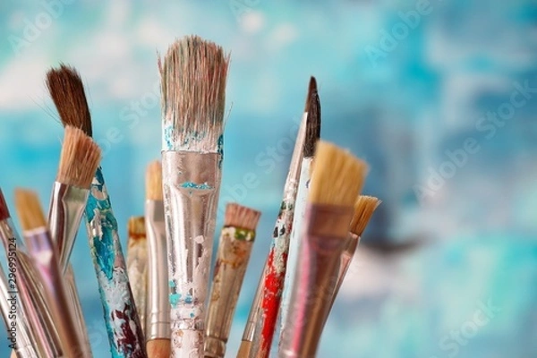 Obraz Paint brushes in front of blurred canvas