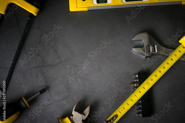 Obraz yellow hardware tools on black concrete background with some space for text
