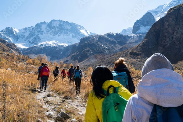 Obraz A team of tourists goes to the rocky mountains.
