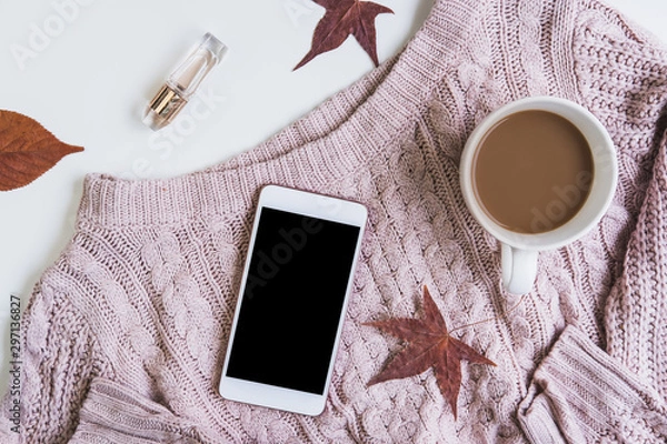Fototapeta Empty screen smartphone with cup of coffee and dried autumn leaves and sweater, Top view