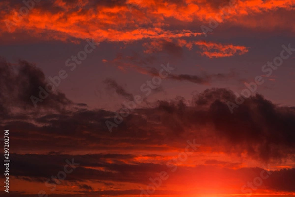 Fototapeta Fiery orange sunset  colorful and speckled  clouds.