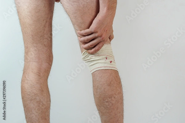 Obraz caucasian man with hands on the back of the knee on White isolated background