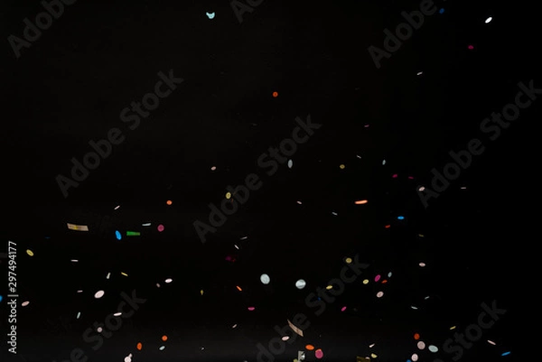 Fototapeta colorful party confetti flying in front of black