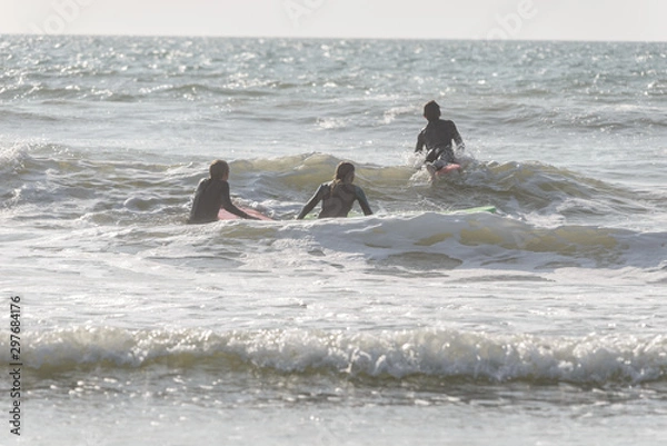 Fototapeta group of surfers in action during summer