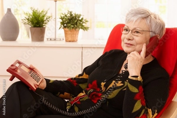 Obraz Emerytka korzystająca z telefonu stacjonarnego