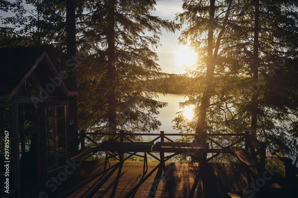 Fototapeta Sunset lake view from a typical summer cottage with sauna in Finland.