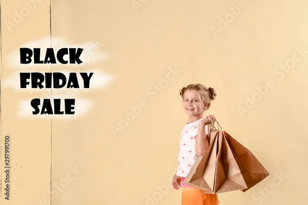 Fototapeta black friday sale.fashionable child in trendy suit jumping with craft package, big purchases not a bright yellow background. black friday banner concept.