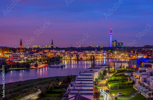 Fototapeta Niesamowity widok na jezioro Phoenix w Dortmundzie w Niemczech na panoramę miasta i wieżę Florian oświetloną o zmierzchu