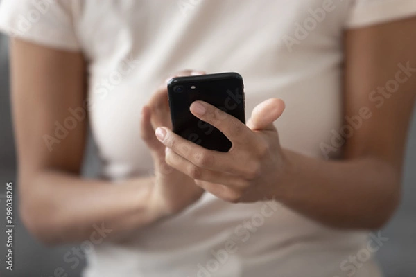 Fototapeta Close up of black woman using smartphone messaging