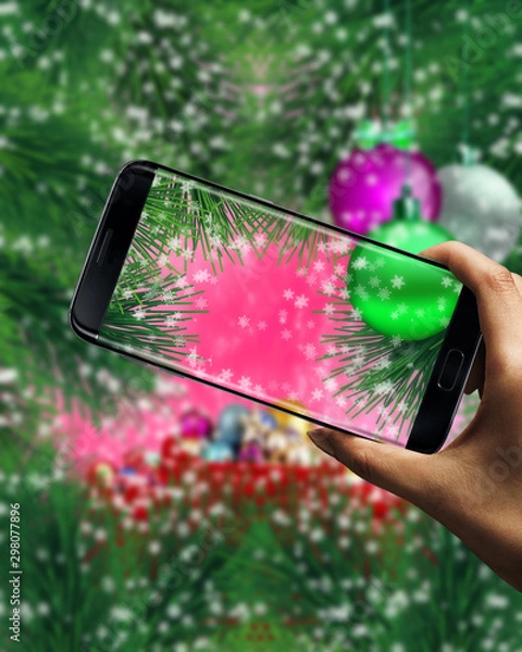 Fototapeta Christmas background with Christmas tree branches and Christmas decorations. Greeting card, banner. Theme of winter, New Year's holidays. Happy New Year. Space for text. Mobile phone in hand
