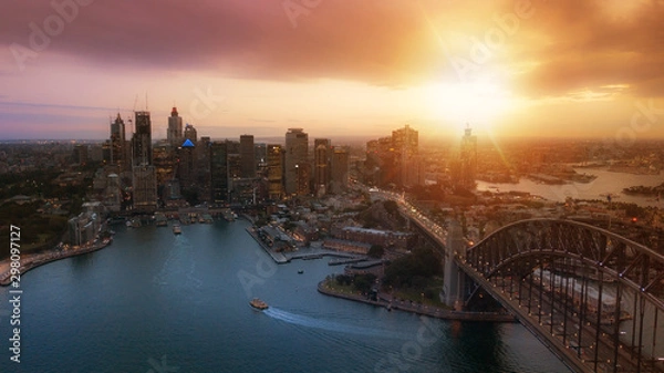 Fototapeta Aerial view of Sydney City during amazing golden sunset with Opera House and Harbour bridge in frame.Small amount of grain due to low light shot.All logotype removed.