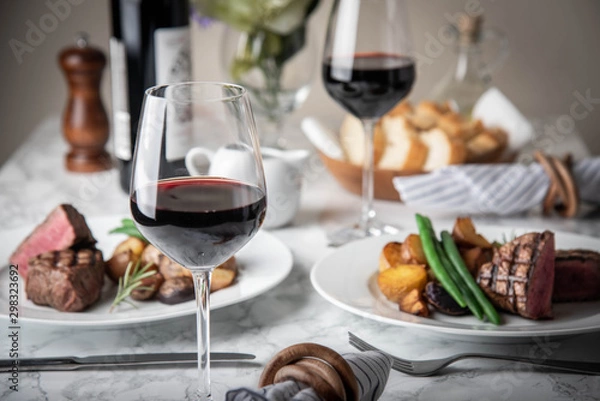 Obraz wine glasses on dining table with steak