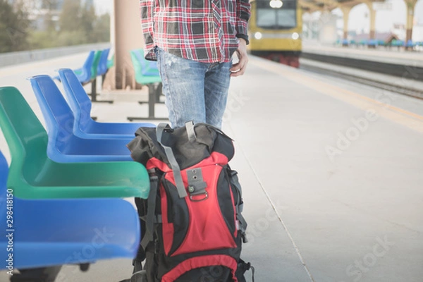 Obraz Men wearing a red plaid shirt and standing waiting for the train at train station. Vintage tone