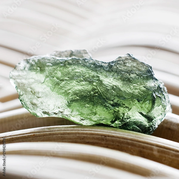 Fototapeta Macro photography of a moldavite stone on a wicker background