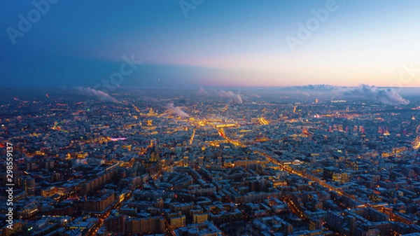 Fototapeta Piękny widok z lotu ptaka na miasto Moskwa na zachód słońca. Malowniczy ruch wieczornej metropolii z stopniowo włączającymi się światłami ulic i budynków oraz kolorowym niebem w tle.