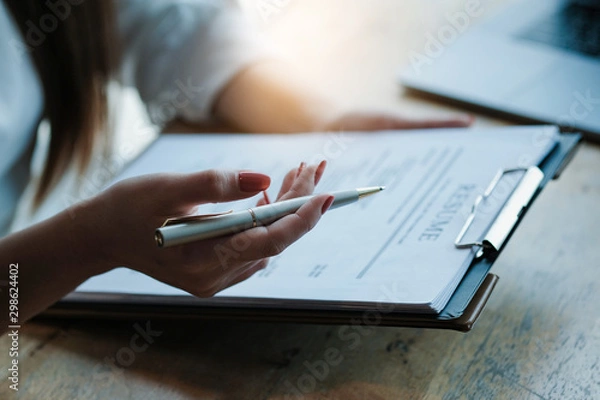 Fototapeta Interviewer reading a resume, Person submits job application, Person describe yourself to interviewer, focus on resume, recruiter considering application, hr manager making hiring decision