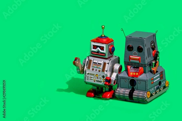 Fototapeta Two antique tin toy robot on green background. Vintage and classic concept free copy space for text.