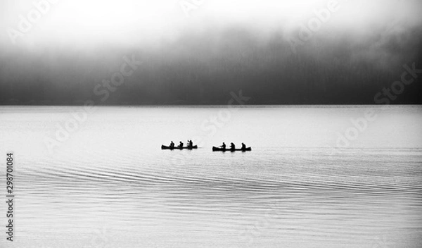 Fototapeta canoe paddle boats on misty foggy lake, black and white bw silhouette, mysterious