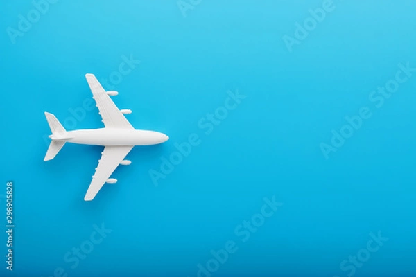 Fototapeta Passenger Model airplane on a blue background. Free space for text.