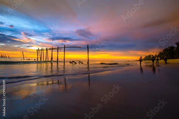 Fototapeta The blurry background of the colorful night sky on the large lake, the brightness of the light that hits the water surface and the wind blows cool, with the rotten wooden bridge over time, a viewpoint