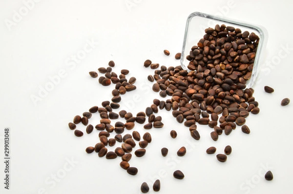 Fototapeta Vitamins of group B, D. Pine nuts in skarlupe on an isolated white background.