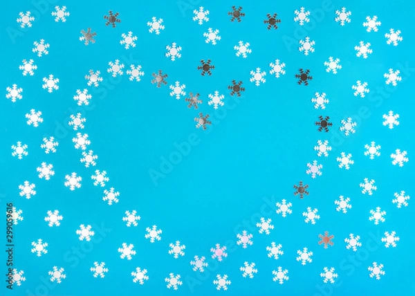 Fototapeta Christmas decorative background. Snowflakes lined with hearts on a blue background.
