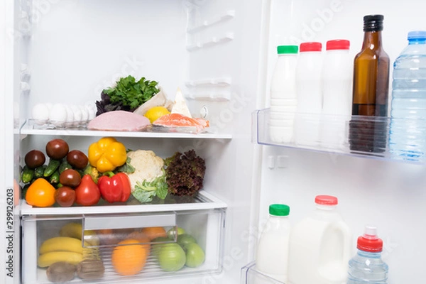 Obraz vegetables and fruits lie inside a white open refrigerator