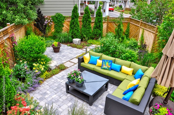 Obraz A beautiful small, urban backyard garden featuring a tumbled paver patio, flagstone stepping stones, and a variety of trees, shrubs and perennials add colour and year round interest. 