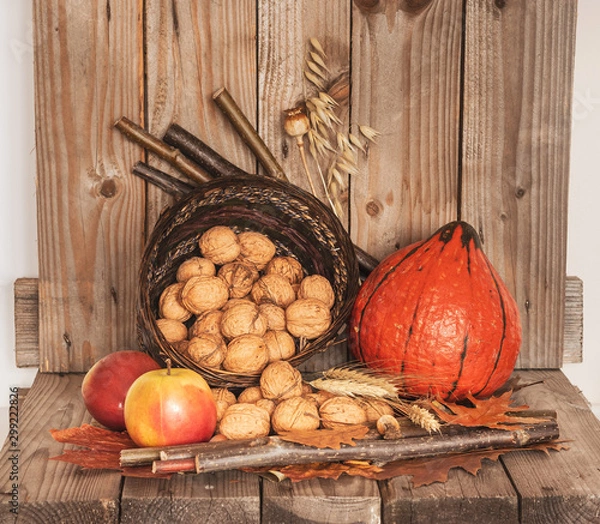 Fototapeta Thanksgiving Day decoration with pumpkin, apples  and basket of walnuts. Rustic decoration.
