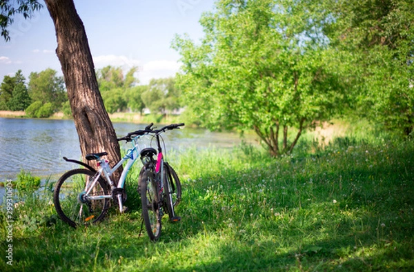 Obraz two bicycles stand on the Bank of the river