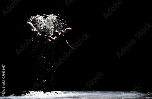 Obraz Chef hand clap and white flour on black background