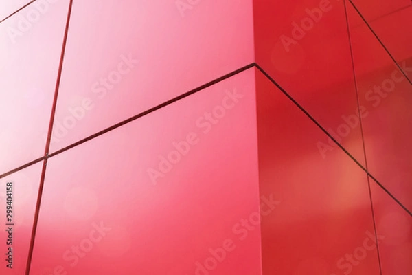 Fototapeta Geometric color elements of the building's facade with planes, lines, corners with highlights and reflections for an abstract background and texture of red, orange colors. Place for text