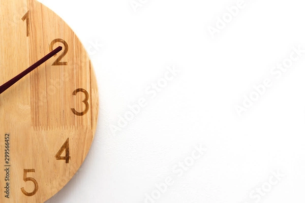 Fototapeta The concept close up of a clock the minute hand points to two number. White background with copy space.