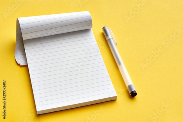 Fototapeta Top view of blank open notebook page with lines and transparent minimalistic fineliner pen on yellow background with copy space. For use as mock up.    