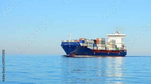 Fototapeta Large cargo container ship sailing in a bright sunny day. Riga, Latvia