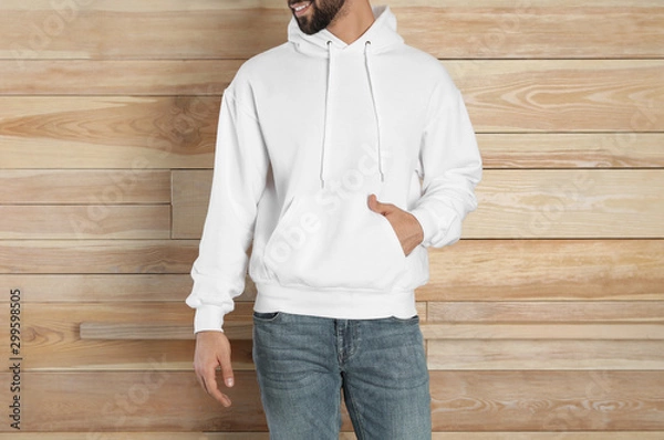 Fototapeta Young man in sweater at wooden wall, closeup. Mock up for design