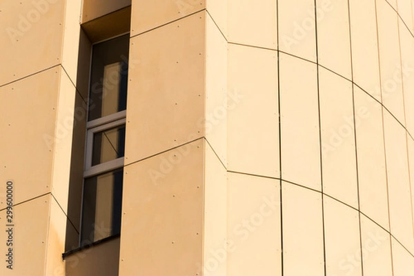 Fototapeta Geometric color elements of the building's facade with planes, lines, corners with highlights and reflections for an abstract background and texture of red, orange colors. Place for text