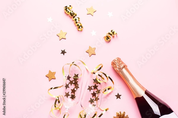 Fototapeta Two champagne glasses with confetti and streamers, golden champagne bottle, green natural fir tree on pastel pink background, copy space. Festive flat lay composition for Christmas or New Year
