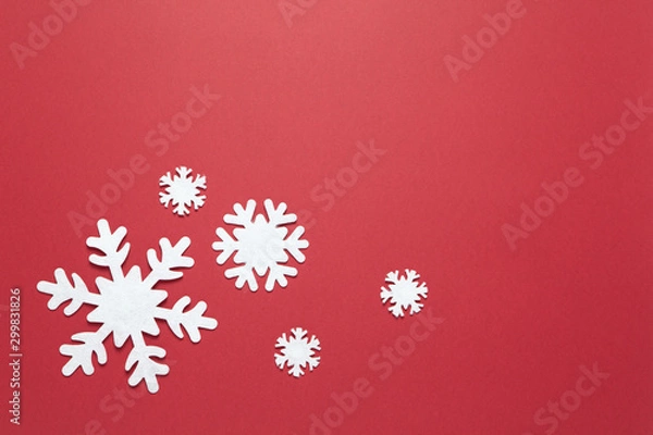 Fototapeta Christmas composition, group of big and small white felt snowflakes on burgundy red background, copy space. Festive, New Year concept. Horizontal, flat lay. Minimal style. Top view