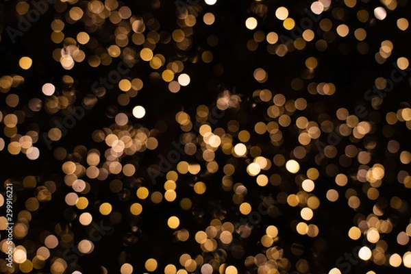 Fototapeta Blurry golden and white fairy string lights in dark night creating beautiful bokeh effect with glowing circles or shiny dots, abstract image for Christmas or holiday card, banner or background