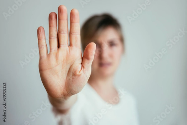 Fototapeta Defense or stop gesture: Girl hand with stop gesture
