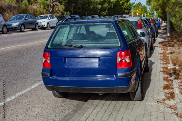 Fototapeta Cars or automobiles parked over the curb into sidewalk, leaving no space for pedestrians in the walkway. Road accessing a suburban railway. Illegal and abusive parking