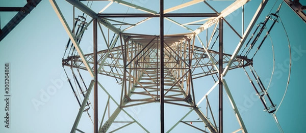 Fototapeta Close up of electrical tower and blue sky. Renewable energy and smart grid.