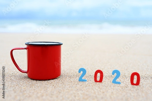Fototapeta Coffee cups and 2020 welcome the new year on the morning beach.