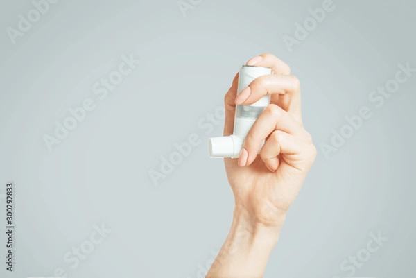 Obraz Ręka trzyma medyczny inhalator astmy.