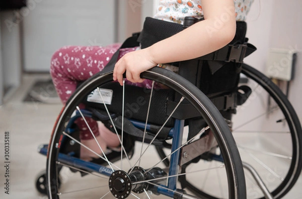 Obraz close-up hand of a child on a wheel from a wheelchair. Disabled children concept.