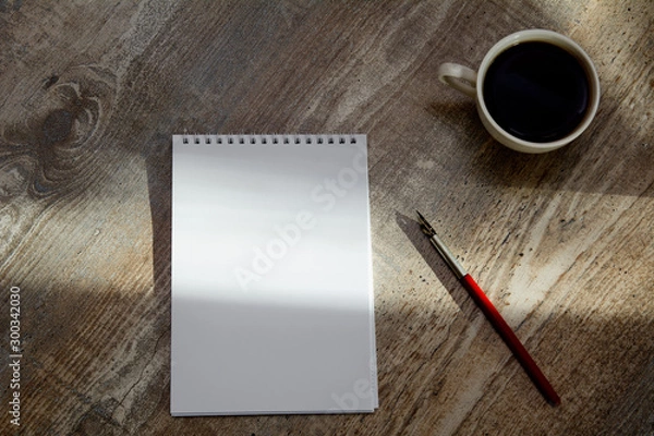 Fototapeta on the table is a notebook, vintage fountain pen and a cup of coffee. Concept - coffee break, business, accountant. Copy space, Top view
