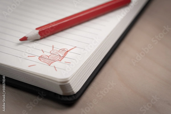 Fototapeta love hearts on notebook with red pen over a wooden table. Suitable for love, valentine, anniversary, couple and friendship concepts.