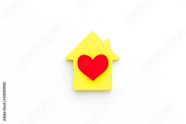 Fototapeta Happy life and home concept. House cutout and heart icon on white background top view copy space